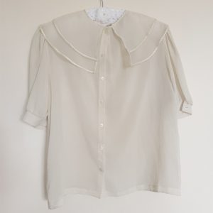 cream blouse hanging on hanger